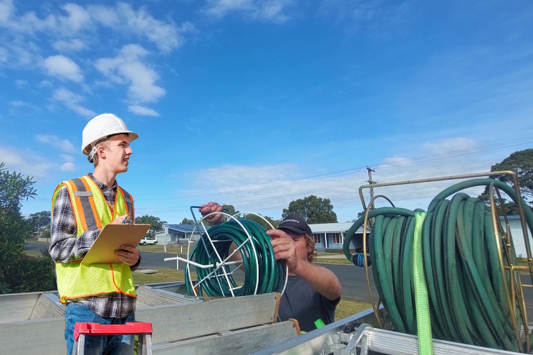
Post-gutter rinsing, ulladulla gutter cleaner loads up his hose system.